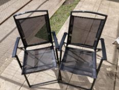 A pair of black folding garden chairs