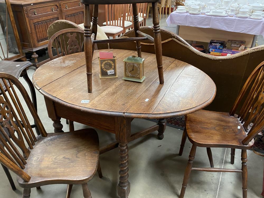 An oval drop leaf table with 4 wheel back chairs - Image 2 of 2