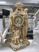 A classical design clock with figures on either side and a cherub in front.