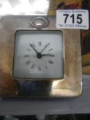 A small clock with silver front.