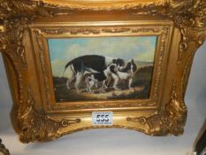 A gilt framed study of a dog with puppies.