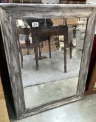 A large grey framed mirror