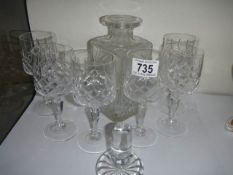 A cut glass decanter with six glasses.