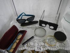 A quantity of magnifying glasses and spectacles.