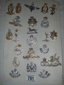 A quantity of replica military cap badges.