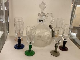 An Engraved decanter with six engraved glasses on coloured glass stems.