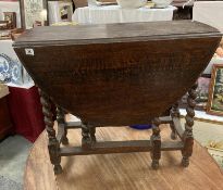 A dark oak oval drop leaf table with Barley twist legs COLLECT ONLY