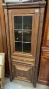 A medium oak effect cupboard with glazed and leaded cupboard containing glass shelves. COLLECT ONLY