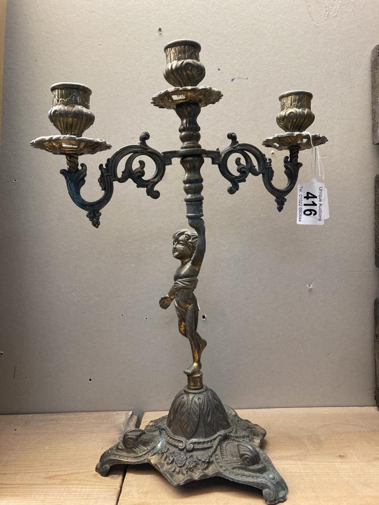 A Brass candelabra featuring a cherub