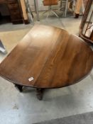 An oak drop leaf table with turned legs and solid supports 100 w x 44 long plus two 47cm leaves oval