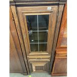 A medium oak effect cupboard with glazed and leaded upper cupboard containing two glass shelves,