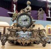 A French spelter mantel clock with hand painted panel with porcelain panel and face filled with