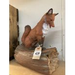A ceramic fox sitting on log signed Yozie Height 28cm, Width 20cm, Depth 14cm
