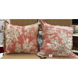 A pair of feather cushions with vintage style cushion covers