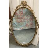 An oval metal framed mirror