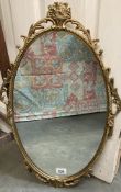 An oval metal framed mirror