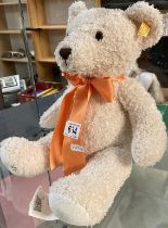 A Steiff bear with orange ribbon