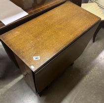 A drop leaf table with central storage cabinets