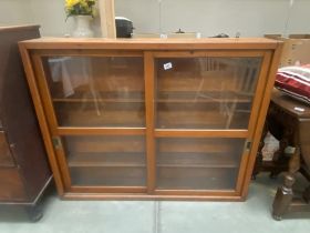 A vintage pine bookcase with sliding glazed doors