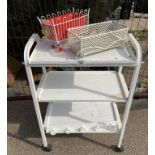 A white metal 3 shelf beauticians style trolley and two small planters
