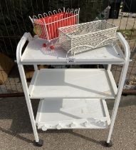 A white metal 3 shelf beauticians style trolley and two small planters
