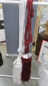 A pair of red wine curtain tie backs with gem style embellishment and tassels [1 slightly lighter
