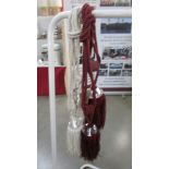 A pair of white curtain tie backs with gem / bead effect embellishment and tassels and a pair of