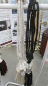 A pair of black curtain tie backs with gem / bead effect embellishment and tassels and a pair of