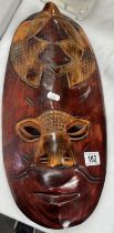 A carved wood wall plaque mask