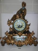 A good 20th century mantel clock surmounted figure and with handpainted dial and panel, with battery