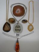 An amber pendant, two agate pendants, two agate brooches etc.,