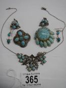 A necklace, two brooches and two pairs of earrings set turquoise coloured stones.