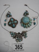 A necklace, two brooches and two pairs of earrings set turquoise coloured stones.