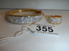 A good quality yellow metal sparkly bangle with matching ring.