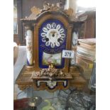 A late Victorian mantle clock with painted panels, in working order but missing hands.