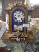A late Victorian mantle clock with painted panels, in working order but missing hands.