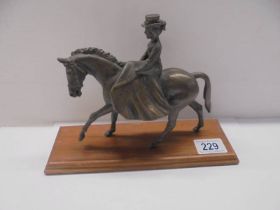 A bronze figure of a lady riding a horse side saddle, length 18cm, height 15.5 cm.