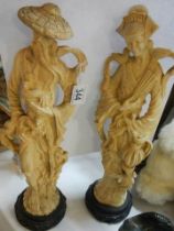 A pair of tall resin oriental male and female figures.