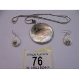 A silver shell pendant and earrings.