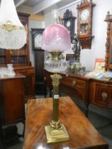 A brass Corinthian column oil lamp with original shade. COLLECT ONLY.