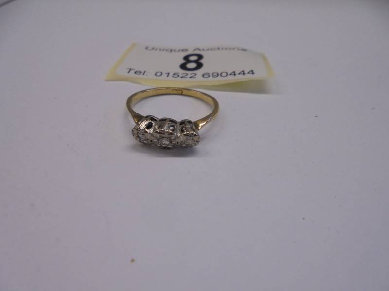 An 18ct yellow gold three stone diamond ring, size L, 2 grams.