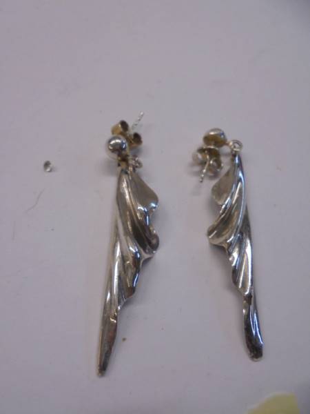 A pair of silver pendant earrings.