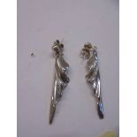 A pair of silver pendant earrings.