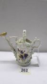 A superb antique porcelain watering can encrusted with flowers.
