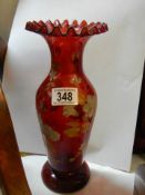 A red glass hand painted vase with frilled rim.