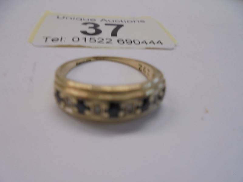 A sapphire and white stone set band ring in 9ct gold shank, size L, 2 grams.
