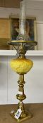 A 19th century brass drop in font candlestick oil lamp with yellow glass font and chimney.