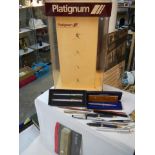A mid 20th century Platignum fountain pen display stand and old pens, COLLECT ONLY.
