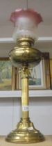 A brass Corinthian column oil lamp with later etched glass shade. COLLECT ONLY.