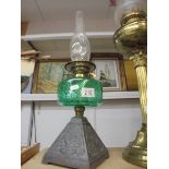 An early 20th century oil lamp on cast iron base with green glass font and chimney. COLLECT ONLY.